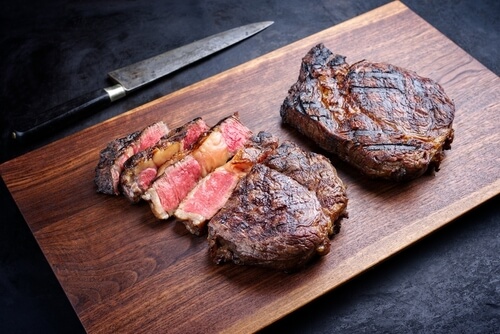 sliced delmonico steak on a cutting board
