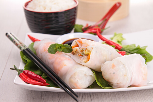 three spring rolls sit on a white plate