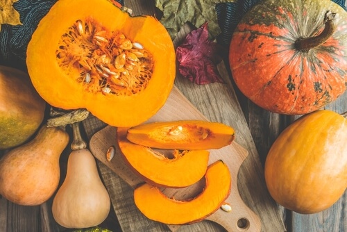 pumpkins and gourds sit on a wooden table